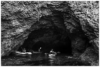 Kayakers at the entrance of sea cave, Santa Cruz Island. Channel Islands National Park ( black and white)