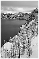 Cliffs, conifer trees, and lake in winter with cloudy skies. Crater Lake National Park ( black and white)