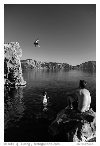Man jumping from cliff as others look, Cleetwood Cove. Crater Lake National Park (black and white)