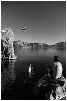 Man jumping from cliff as others look, Cleetwood Cove. Crater Lake National Park ( black and white)
