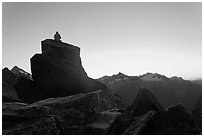 Man sitting on rock contemplates mountains at sunrise, North Cascades National Park.  ( black and white)