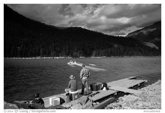 Guests waiting for ride across lake to Ross Lake resort, North Cascades National Park Service Complex.  (black and white)