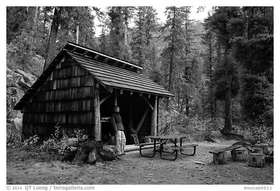 Hiker at high Bridge campground shelter, North Cascades National Park.  (black and white)