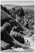 Hikers approaching cliff with steps carved in stone. Pinnacles National Park ( black and white)