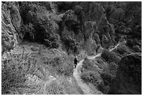 Hiker on trail in spring. Pinnacles National Park, California, USA. (black and white)