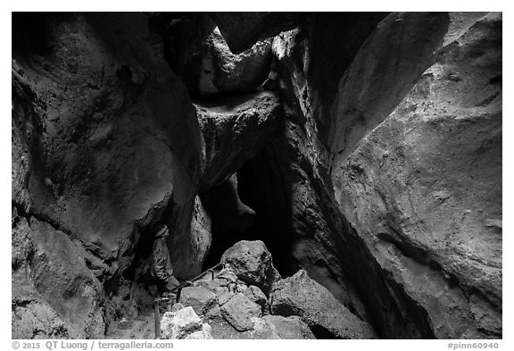 Hiker looking from staircase down into Lower Bear Gulch Cave. Pinnacles National Park (black and white)