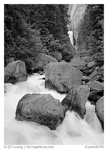 Boulders in frosty Merced River and distant Vernal Fall. Yosemite National Park, California, USA.
