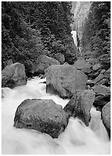 Boulders in frosty Merced River and distant Vernal Fall. Yosemite National Park, California, USA. (black and white)