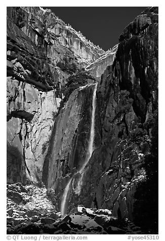 Lower Yosemite Falls and rock wall with snowy trees on rim. Yosemite National Park (black and white)