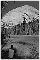 Hiker sitting at Lost Lake on west side Half-Dome. Yosemite National Park, California, USA. (black and white)