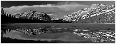 Mountains reflected in partly iced Tenaya Lake. Yosemite National Park (Panoramic black and white)