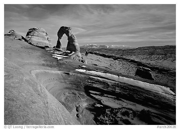 Sandstone bowl, Delicate Arch, and La Sal Mountains with snow, sunset. Arches National Park (black and white)