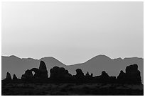 Turret Arch, spires, and mountains at dawn. Arches National Park, Utah, USA. (black and white)