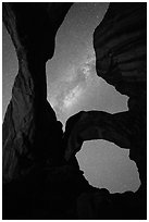 Milky Way appearing above Double Arch. Arches National Park, Utah, USA. (black and white)