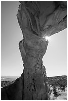 Sunburst at the crack of Broken Arch. Arches National Park, Utah, USA. (black and white)