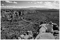 Tourist taking picture from top of fin. Arches National Park, Utah, USA. (black and white)
