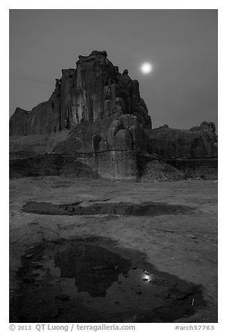 Courthouse tower and moon at night. Arches National Park, Utah, USA.