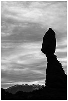 Balanced Rock silhouetted against La Sal Mountains and sky. Arches National Park, Utah, USA. (black and white)
