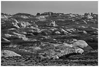 Sandstone domes with arch in background. Arches National Park, Utah, USA. (black and white)