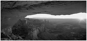 Sunrise and canyon landscape through Mesa Arch. Canyonlands National Park (Panoramic black and white)
