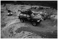 4WD vehicles driving over rock at dusk in Teapot Canyon. Canyonlands National Park ( black and white)