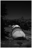 Lit tents at night in the Dollhouse. Canyonlands National Park, Utah, USA. (black and white)