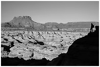 Hiker silhouette above the Maze and Chocolate drops. Canyonlands National Park, Utah, USA. (black and white)