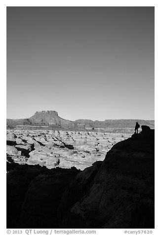 Hiker standing in silhouette above the Maze. Canyonlands National Park (black and white)