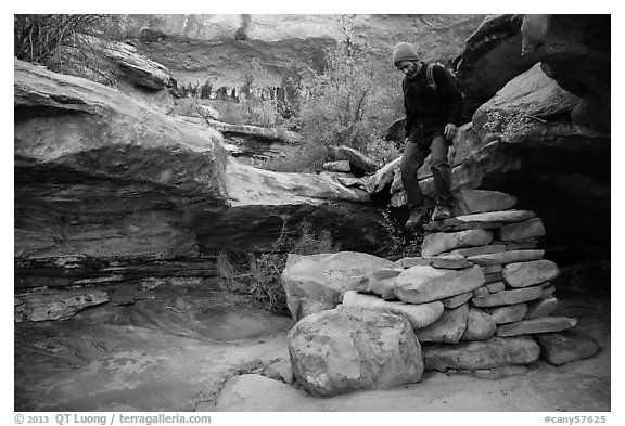 Hiker stepping down on primitive stairs, Maze District. Canyonlands National Park (black and white)