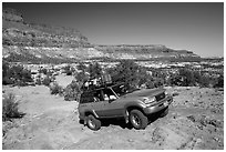 4WD vehicle driving over rocks in Teapot Canyon. Canyonlands National Park ( black and white)