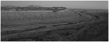 Long chain of cliffs of the Waterpocket Fold at dusk. Capitol Reef National Park (Panoramic black and white)