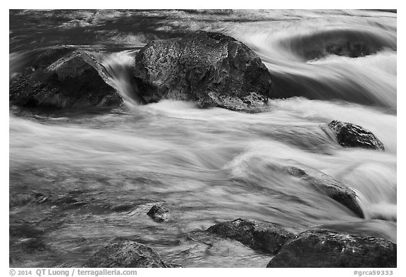 Boulders and rapids with glow from canyon walls reflected. Grand Canyon National Park (black and white)