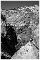 Woman hiker clinging to cable on Hidden Canyon trail. Zion National Park ( black and white)