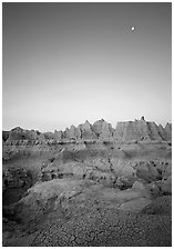 Mud cracks, badlands, and moon at dawn. Badlands National Park, South Dakota, USA. (black and white)