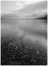 Pebbles, lake Mc Donald, and foggy mountain range, early morning. Glacier National Park ( black and white)