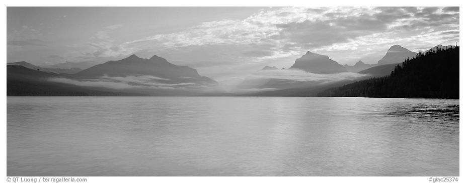 Serene lake with clouds hanging over mountains. Glacier National Park (black and white)