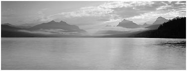 Serene lake with clouds hanging over mountains. Glacier National Park (Panoramic black and white)