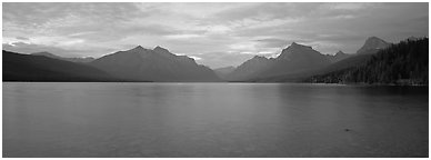Mountains rising above calm lake in the evening. Glacier National Park (Panoramic black and white)