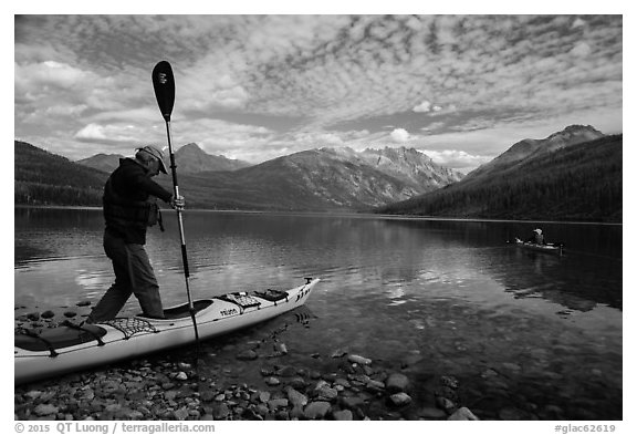 Kayaker steps into kayak, Kintla Lake. Glacier National Park (black and white)