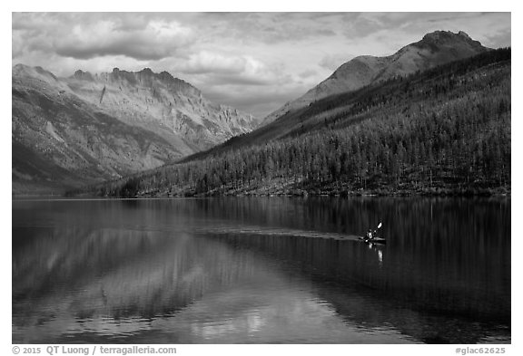 Kayaker paddling back to shore as clouds threaten, Kintla Lake. Glacier National Park (black and white)