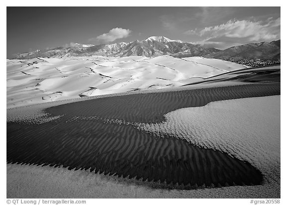 Patch of sand, snow-covered dunes, Sangre de Christo mountains. Great Sand Dunes National Park and Preserve (black and white)