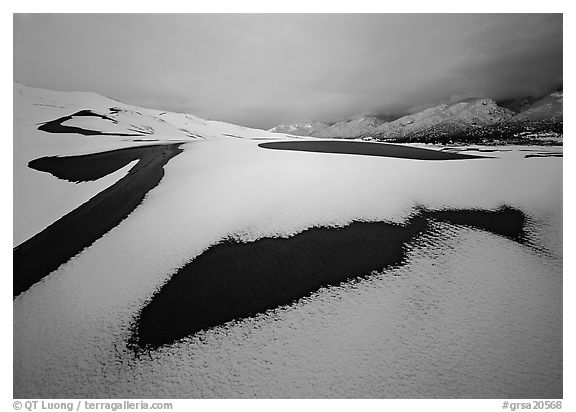 Patch of sand in snow-covered dunes. Great Sand Dunes National Park and Preserve (black and white)