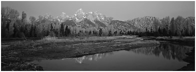 Jagged mountains and autumn colors reflected at sunrise. Grand Teton National Park (Panoramic black and white)