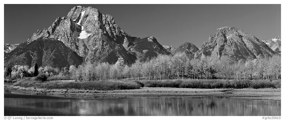 Rugged mountains rising above tree-lined lake in autumn. Grand Teton National Park (black and white)