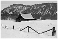Fence and historic Moulton Barn in winter. Grand Teton National Park, Wyoming, USA. (black and white)