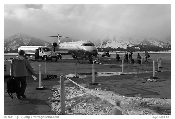 Passengers walking towards plane on Jackson Hole Airport. Grand Teton National Park (black and white)