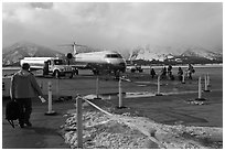 Passengers walking towards plane on Jackson Hole Airport. Grand Teton National Park ( black and white)