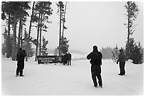 Tourists take pictures with entrance sign in winter. Yellowstone National Park ( black and white)