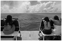 Women sunning themselves on snorkeling boat. Biscayne National Park, Florida, USA. (black and white)