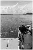 Woman relaxes on snorkeling boat as it enters Caesar Creek. Biscayne National Park, Florida, USA. (black and white)